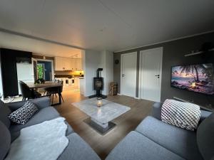 a living room with a couch and a tv on a wall at Flott sommerhus midt i Lillehammer sentrum in Lillehammer