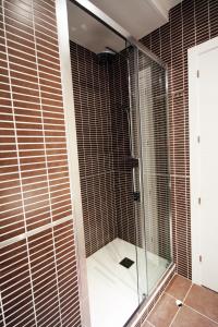 y baño con ducha y puertas de cristal. en Noa Apartment, en Madrid