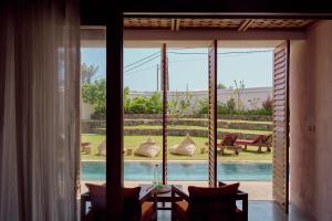 a room with a view of a pool through a glass door at UNU Boutique Hotel -- Adults Only -- in Ahangama