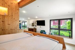 a bedroom with two beds and a flat screen tv at Wohnplatz 52 in Inzigkofen