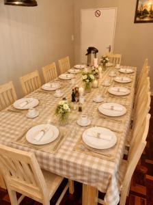 a long table with white plates and flowers on it at Tau Golden Mane in Johannesburg +49 photos