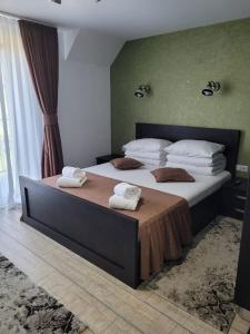 ein Schlafzimmer mit einem großen Bett, auf dem Handtücher liegen in der Unterkunft Casa Sofia Avrig in Avrig + 21 Fotos
