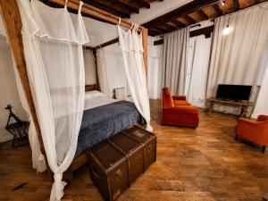 a bedroom with a canopy bed and a chair at Dimora storica - Palazzo Barabesi in Siena