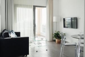 a living room with a glass table and chairs at Coral Bay Garden in Peyia