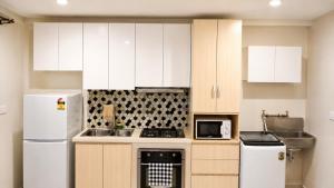 a kitchen with white cabinets and white appliances at The Zef Apartment in Nadi