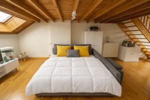 a large white bed with yellow pillows in a room at Loft Chaleureux - Le Chalet Montois in Mons +9 photos
