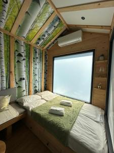 a bedroom with two beds and a large window at Sarajevo jacuzzi sauna Forest romance lodge in Sarajevo