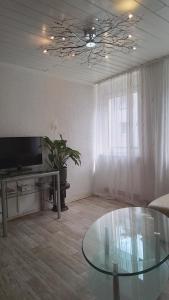 a living room with a glass table and a tv at Ferienwohnung Volskyy in Trier