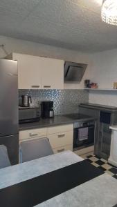 a kitchen with white cabinets and a counter top at Ferienwohnung Volskyy in Trier