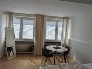 a living room with a table and chairs and windows at HarmoNest 1 Mgladbach South in Mönchengladbach