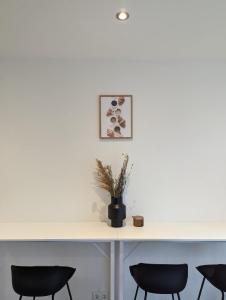 a table with chairs and a vase with flowers on it at HarmoNest 1 Mgladbach South in Mönchengladbach +14 photos
