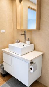 a bathroom with a white sink and a mirror at The Zef Apartment in Nadi