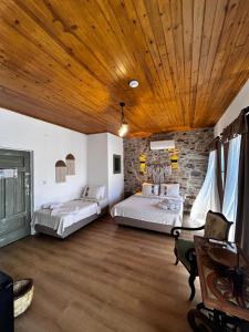 two beds in a room with a wooden ceiling at Chori Avlu Küçükköy in Ayvalık