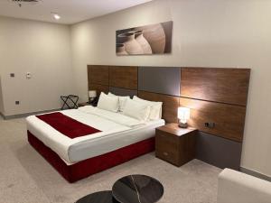 a bedroom with a large bed with a wooden headboard at Garden Hotel in Kuwait