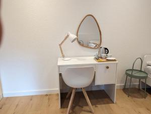 a white desk with a mirror and a chair at HarmoNest 2 Mgladbach south in Mönchengladbach