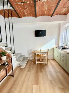a living room with a table and a kitchen at Casetta di Dodo - Charm Toscano in Centro in Collesalvetti