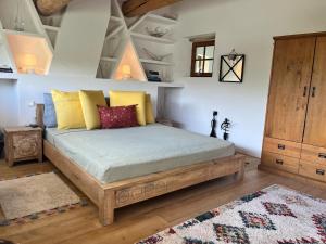 a bedroom with a bed with yellow and red pillows at La Borie Oubliée in Gordes +94 photos