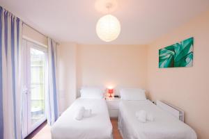 two beds in a room with a window at Town or Country - Clench Street in Southampton