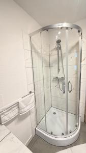 a shower stall in a bathroom with white tiles at Domek 80m2 na wyłączność in Tczew +17 photos