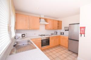 a kitchen with wooden cabinets and a stainless steel refrigerator at Town or Country - Clench Street in Southampton