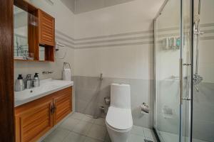 a bathroom with a shower and a toilet and a sink at Heaven Boutique Hotel in Kigali +22 photos