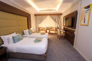 a hotel room with two beds and a table at Diamond Vision Hotel in Jeddah +47 photos