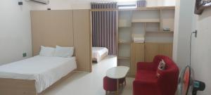 a bedroom with a bed and a red chair at Hiên lương hotel &Apartment in Danang