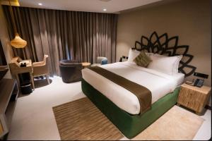 a hotel room with a large bed and a chair at Pixcel Holidays in Calangute