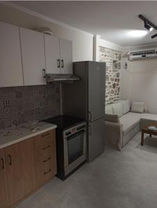 a kitchen with a refrigerator and a couch in a room at Pierres Blanches Center in Mytilene