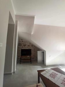 a living room with a couch and a television at Pierres Blanches Center in Mytilene
