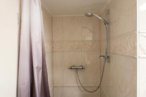 a shower with a shower curtain in a bathroom at Strandnest VILLA KAETHE am Kurpark - gemütliche 60qm Ferienwohnung für Zwei in Warnemünde +5 photos
