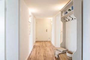 a hallway with white walls and a hard wood floor at Strandnest VILLA KAETHE am Kurpark - gemütliche 60qm Ferienwohnung für Zwei in Warnemünde