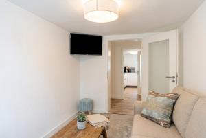 a living room with a couch and a flat screen tv at Strandnest VILLA KAETHE am Kurpark - gemütliche 60qm Ferienwohnung für Zwei in Warnemünde