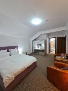 a bedroom with a large bed and a chair at Casa cu pastravi in Sinaia