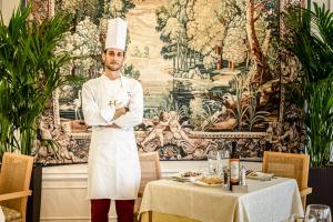 a chef standing in a restaurant with his arms crossed at Hotel Gambrinus in Cervia