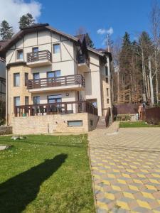 a large house with a stone driveway in front of it at Casa cu pastravi in Sinaia