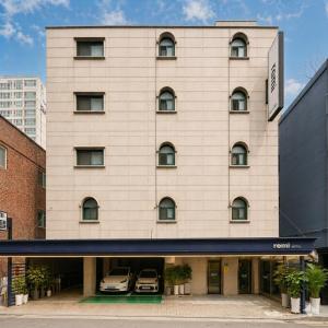 a large white building with two cars parked in it at Hotel Remi in Seoul