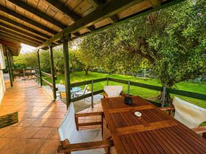 a patio with a wooden table and chairs on a deck at Emerald Cove in Kanali