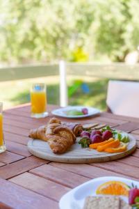 a wooden table with a plate of food and fruit at Emerald Cove in Kanali
