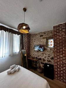 a bedroom with a bed and a brick wall at Chori Avlu Küçükköy in Ayvalık