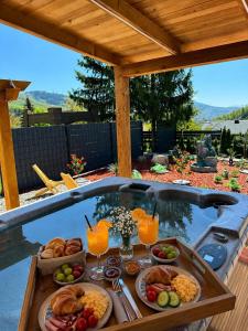 a tray of food on a table next to a pool at Sarajevo jacuzzi sauna Forest romance lodge in Sarajevo