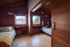 a bedroom with two beds and a window at Winahost Casa Nívar in Nívar