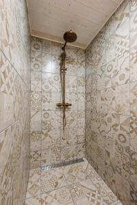 a bathroom with a shower with a tiled wall at Wiedemanni Apartments in Haapsalu +23 photos