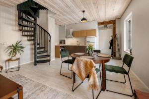 a living room with a table and chairs and a spiral staircase at Wiedemanni Apartments in Haapsalu