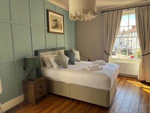 a bedroom with a bed with white sheets and a window at Oak House Hotel in Axbridge