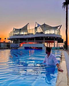 a man in a swimming pool in front of a building at White Tower Mamaia Beach 602 in Mamaia