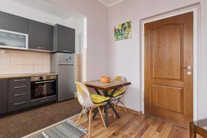 a kitchen with a table and chairs and a door at Maslina Krtoli in Tivat