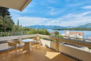 a balcony with chairs and a table and a view of the water at Maslina Krtoli in Tivat