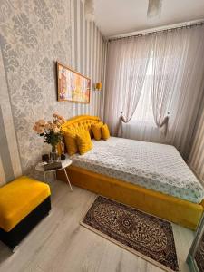 a bedroom with a bed with yellow pillows and a window at Zarisha Home in Fergana +4 photos