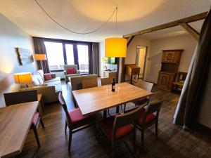 a living room with a wooden table and chairs at Beatenberg Alpine Residence in Beatenberg